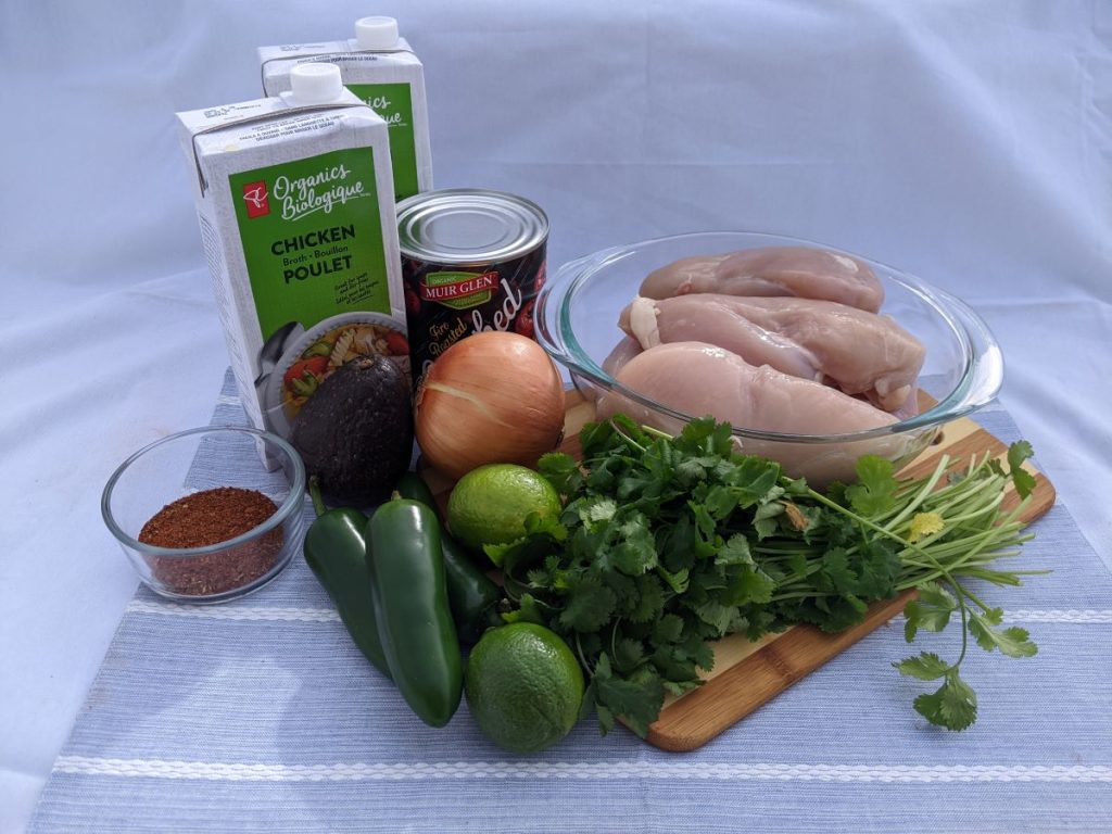 chicken breasts, vegetables, chicken broth and a few other ingredients on a table