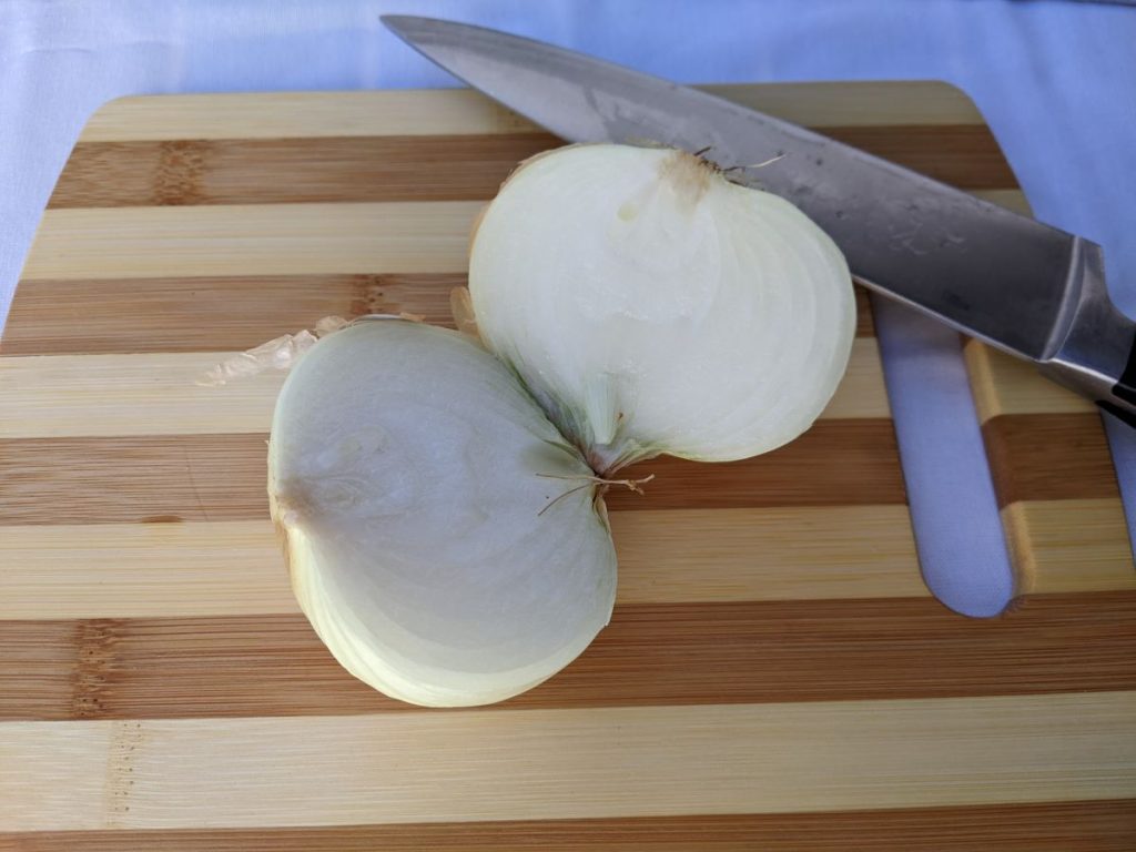 sweet onion cut in half on a cutting board