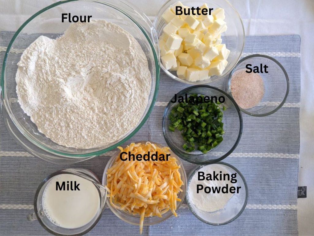 Flour, butter, salt, jalapenos, cheddar, milk, baking powder on a table