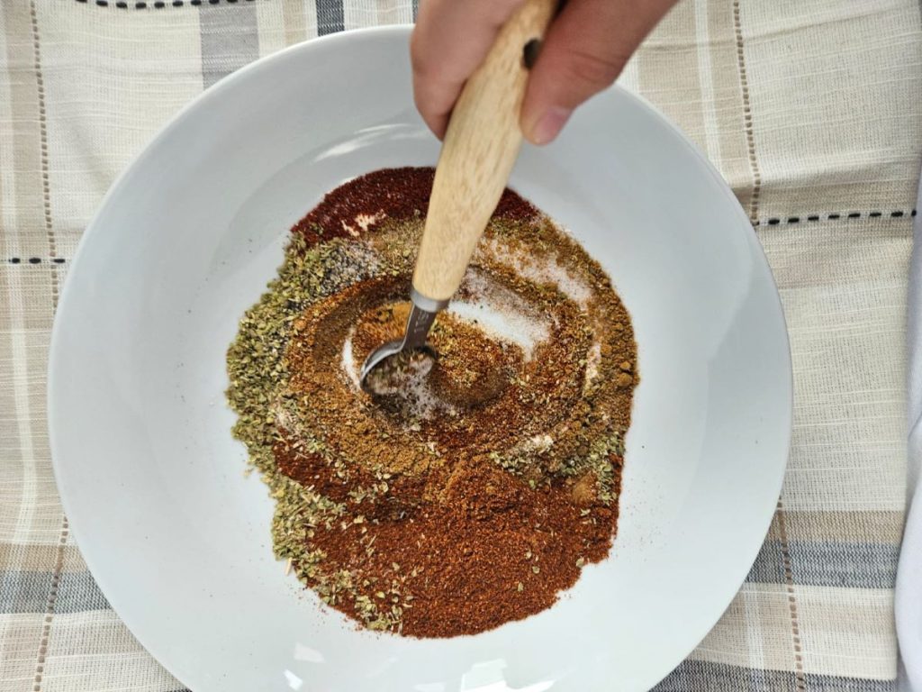 taco seasoning in a bowl being mixed with a spoon
