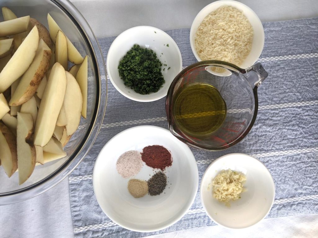 Potato wedges in a bowl with more ingredients surrounding it