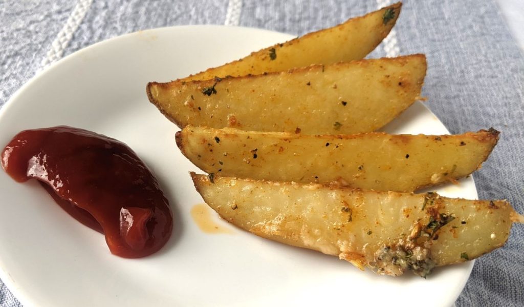 potato wedges on a plate with ketchup