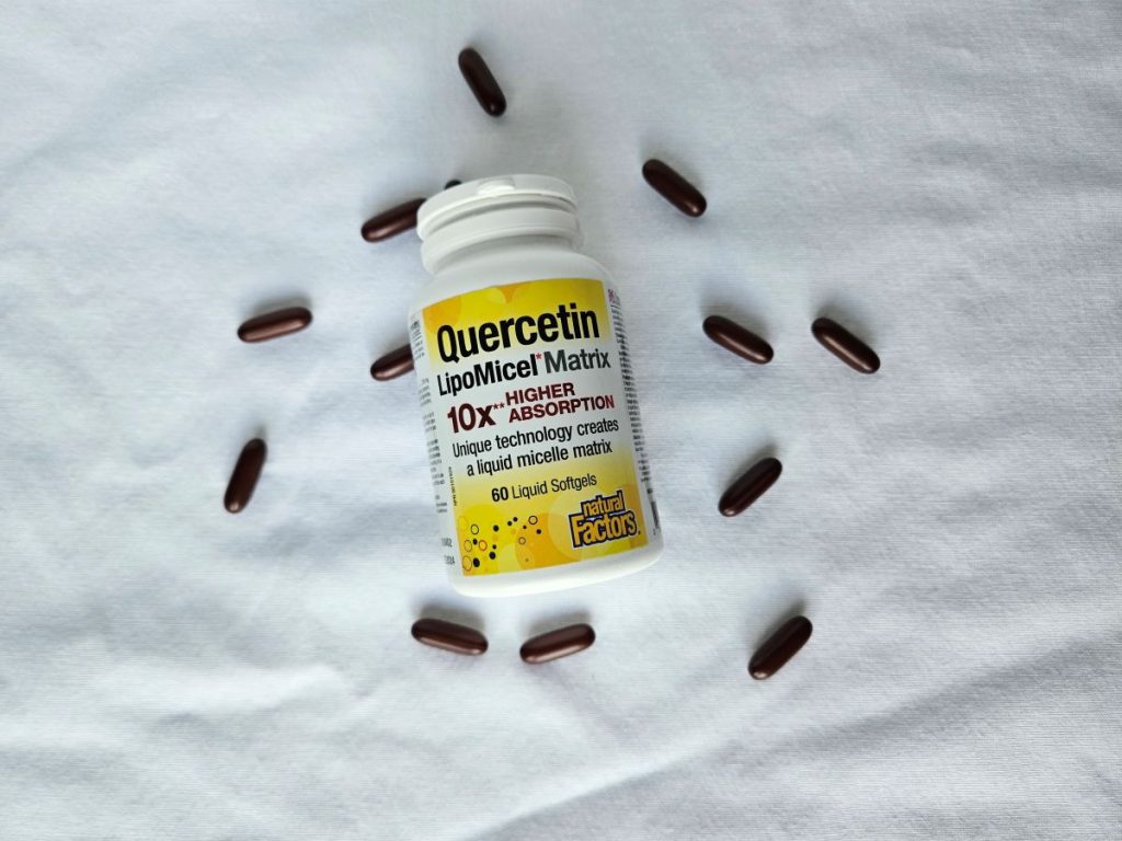 bottle of quercetin with some of the supplements scattered around it
