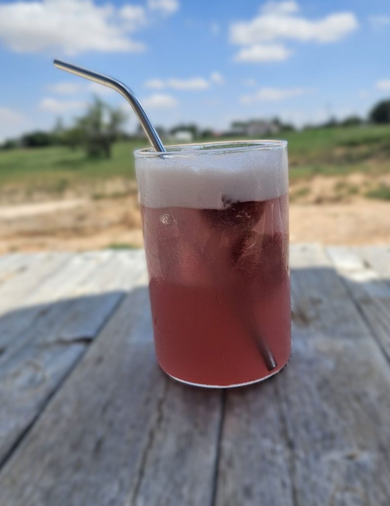 Pink Drink in a glass on a patio 